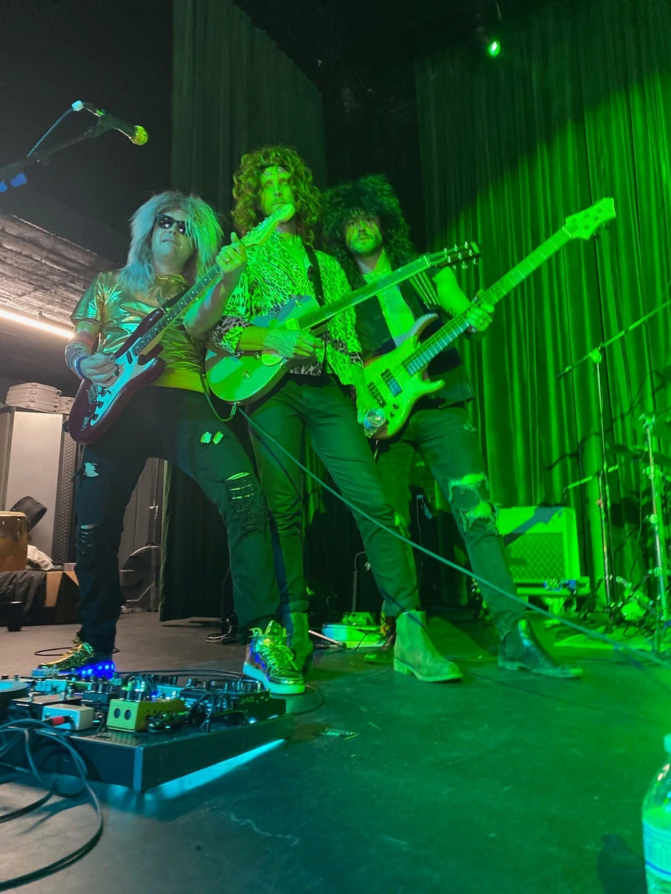Three Walkmans guitarists playing side by side at the front of the stage
